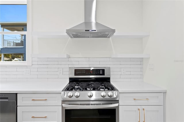 kitchen with white cabinets, wall chimney exhaust hood, tasteful backsplash, and gas stove