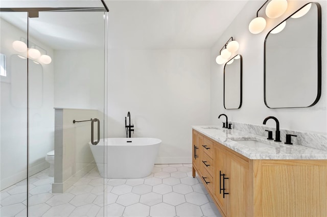 bathroom featuring tile patterned flooring, a washtub, vanity, and toilet