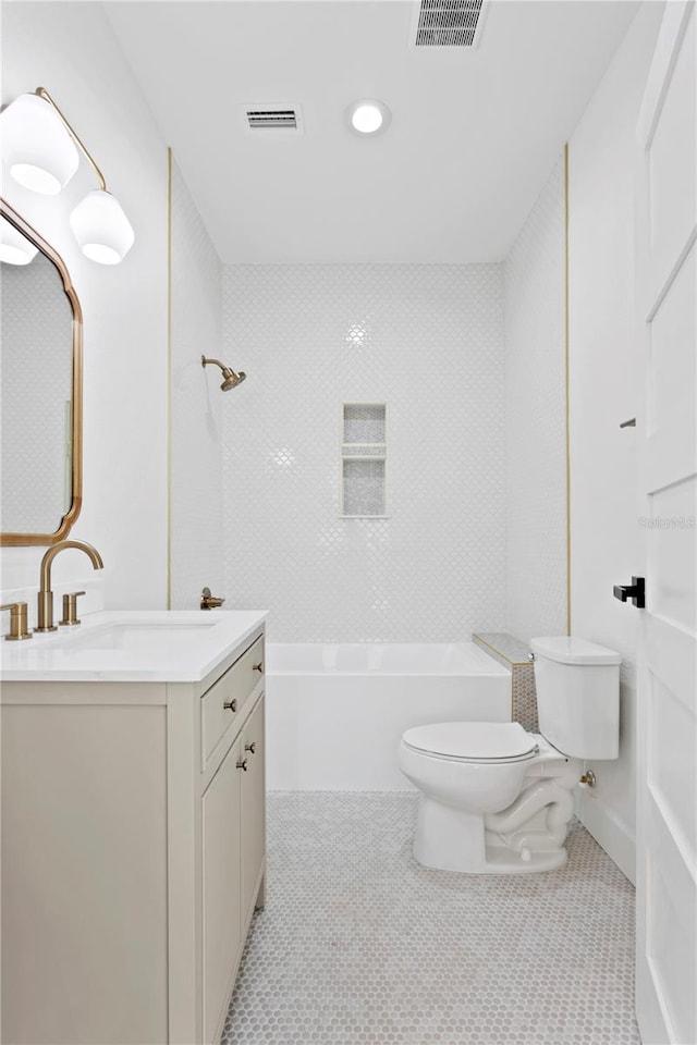 full bathroom featuring tiled shower / bath combo, vanity, tile patterned floors, and toilet