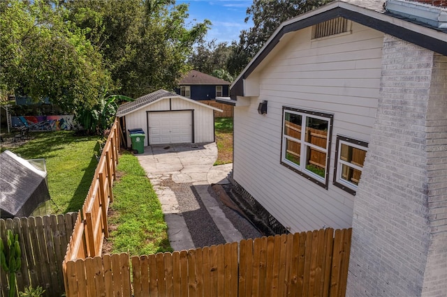 view of side of property featuring a garage, an outdoor structure, and a yard