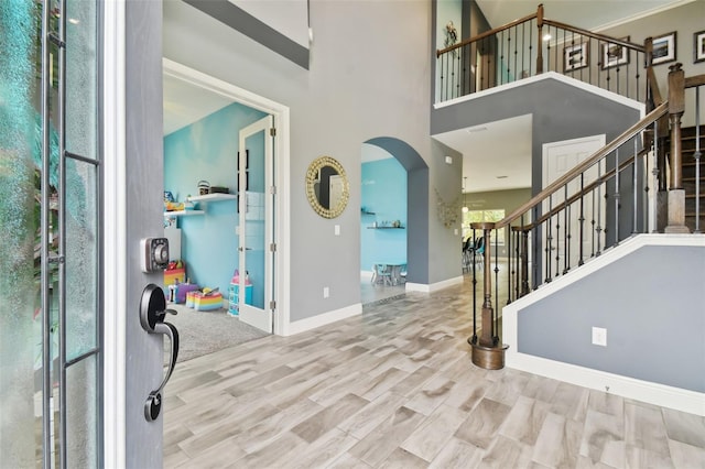 foyer entrance featuring a high ceiling and light hardwood / wood-style floors