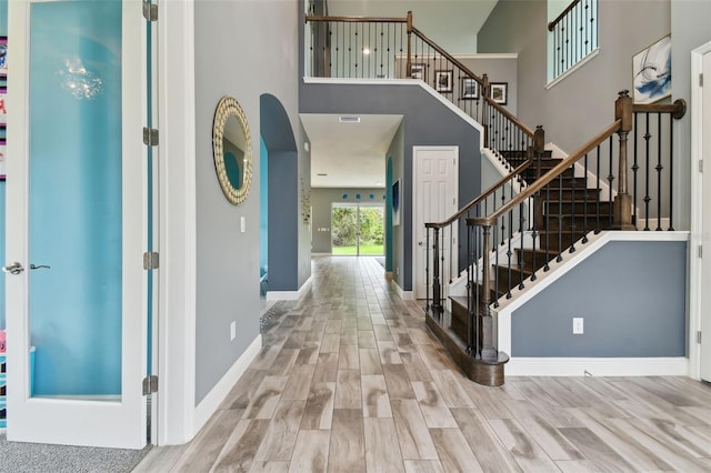 entryway with a high ceiling and light hardwood / wood-style flooring