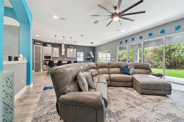 living room with light wood-type flooring and ceiling fan