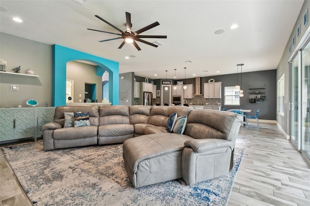 living room with ceiling fan and light hardwood / wood-style flooring