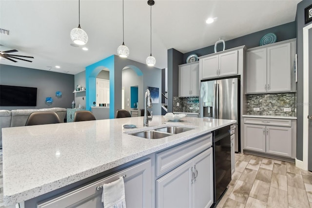 kitchen featuring white cabinetry, sink, ceiling fan, decorative light fixtures, and a kitchen island with sink