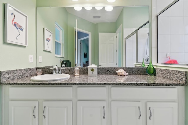 bathroom featuring an enclosed shower and vanity