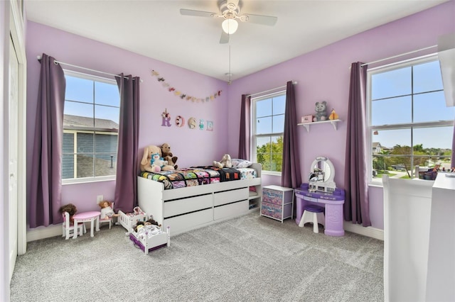 carpeted bedroom with multiple windows and ceiling fan