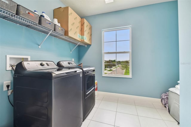 washroom with washer and dryer and light tile patterned flooring