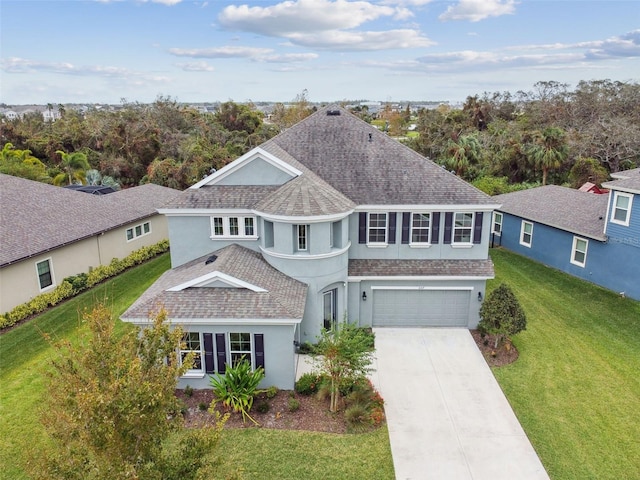 6317 Brevada Ln, Apollo Beach, FL 33572 - view of front of house featuring stucco siding, roof with shingles, concrete driveway, an attached garage, and a front lawn