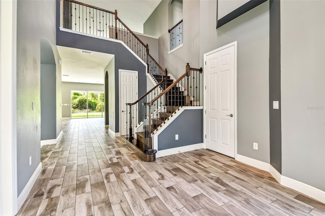 6317 Brevada Ln, Apollo Beach, FL 33572 - foyer entrance with wood finished floors, a towering ceiling, baseboards, and stairway