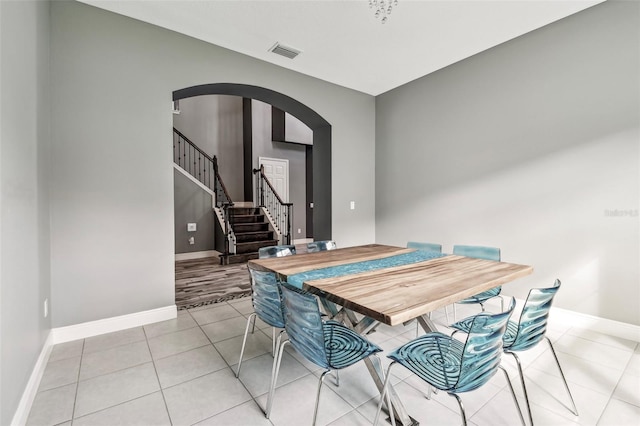 6317 Brevada Ln, Apollo Beach, FL 33572 - dining space with arched walkways, baseboards, light tile patterned flooring, and stairs