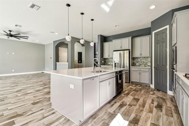 6317 Brevada Ln, Apollo Beach, FL 33572 - kitchen featuring arched walkways, ceiling fan, light wood finished floors, decorative backsplash, and recessed lighting