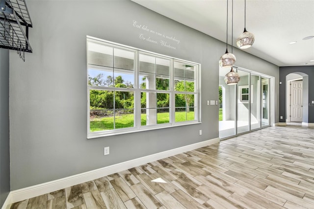 6317 Brevada Ln, Apollo Beach, FL 33572 - unfurnished dining area with arched walkways, baseboards, wood finished floors, and recessed lighting