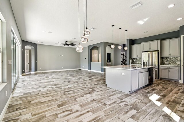 6317 Brevada Ln, Apollo Beach, FL 33572 - kitchen with arched walkways, dishwasher, decorative backsplash, ceiling fan, and recessed lighting