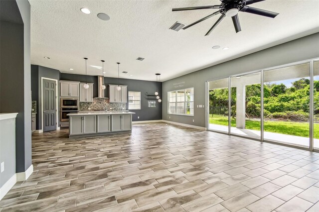 6317 Brevada Ln, Apollo Beach, FL 33572 - unfurnished living room with plenty of natural light, a ceiling fan, baseboards, a textured ceiling, and recessed lighting