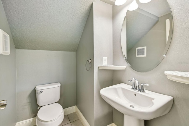 6317 Brevada Ln, Apollo Beach, FL 33572 - half bath with lofted ceiling, toilet, a sink, tile patterned floors, and a textured ceiling