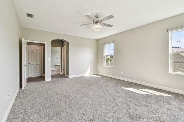 6317 Brevada Ln, Apollo Beach, FL 33572 - empty room with arched walkways, a ceiling fan, plenty of natural light, and carpet floors