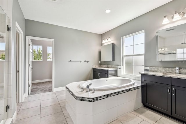 6317 Brevada Ln, Apollo Beach, FL 33572 - full bath with a garden tub, tile patterned flooring, a stall shower, two vanities, and baseboards