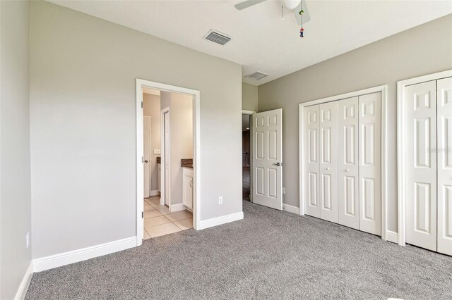 6317 Brevada Ln, Apollo Beach, FL 33572 - unfurnished bedroom featuring carpet flooring, multiple closets, baseboards, ensuite bath, and tile patterned floors