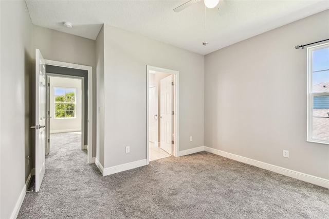 6317 Brevada Ln, Apollo Beach, FL 33572 - unfurnished bedroom featuring carpet flooring, baseboards, connected bathroom, and ceiling fan