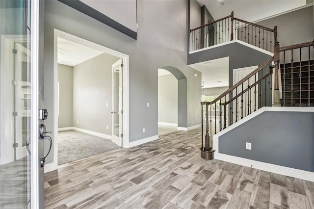 6317 Brevada Ln, Apollo Beach, FL 33572 - foyer with stairs, arched walkways, wood finished floors, and baseboards