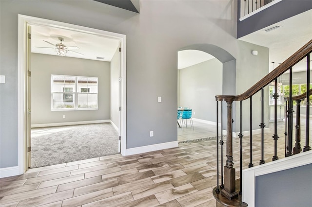 6317 Brevada Ln, Apollo Beach, FL 33572 - entrance foyer with arched walkways, baseboards, ceiling fan, stairs, and wood finish floors