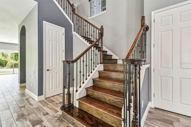 6317 Brevada Ln, Apollo Beach, FL 33572 - stairway featuring arched walkways, baseboards, and wood finished floors