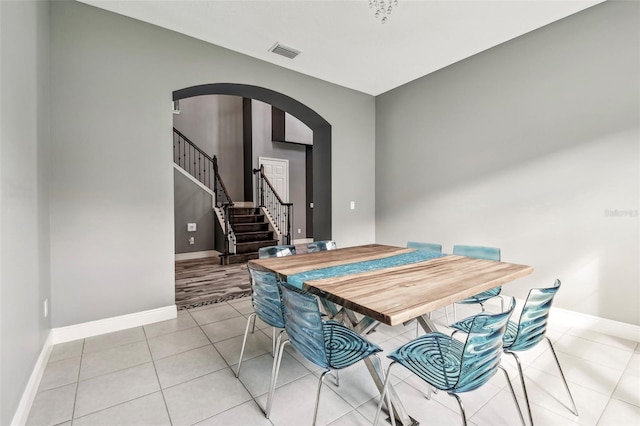 6317 Brevada Ln, Apollo Beach, FL 33572 - dining space featuring arched walkways, baseboards, light tile patterned floors, and stairs