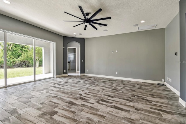 6317 Brevada Ln, Apollo Beach, FL 33572 - empty room with a textured ceiling, recessed lighting, arched walkways, ceiling fan, and baseboards