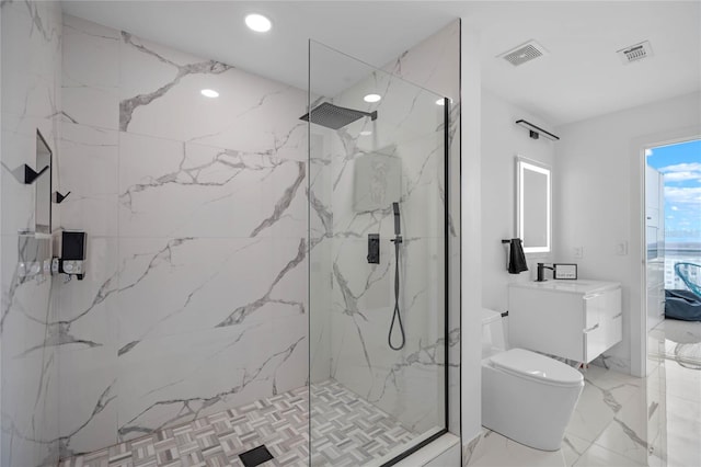 bathroom with vanity, tiled shower, and toilet