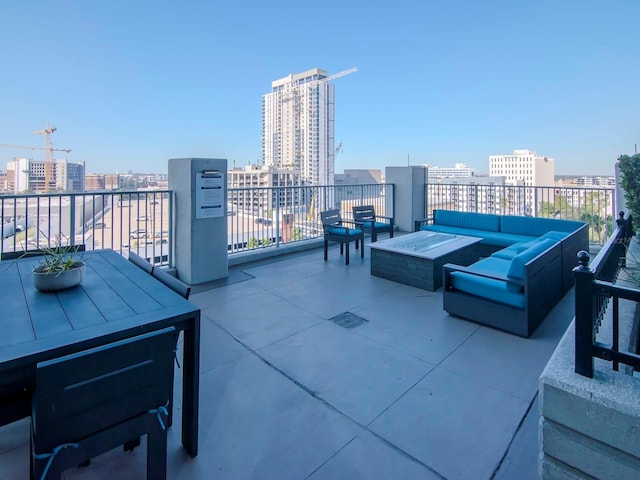 view of patio / terrace featuring a balcony and an outdoor living space with a fire pit