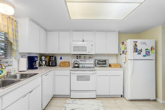 kitchen featuring white appliances, white cabinetry, and sink