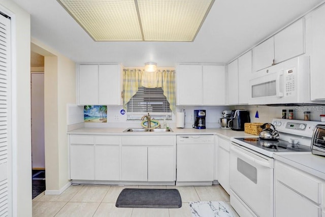 kitchen featuring white appliances, backsplash, white cabinetry, and sink