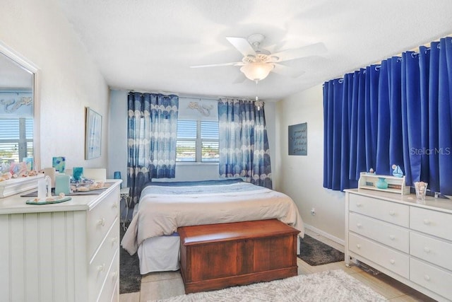 bedroom with ceiling fan, multiple windows, and light tile patterned floors