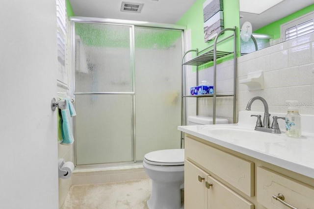 bathroom featuring tile patterned flooring, vanity, an enclosed shower, and toilet