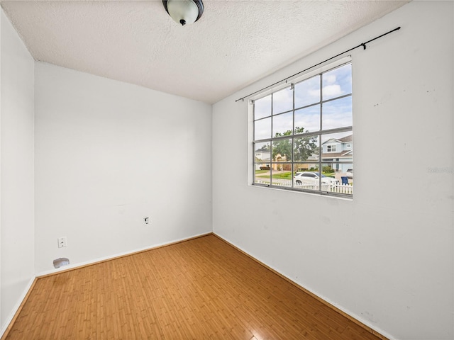 unfurnished room featuring hardwood / wood-style floors and a textured ceiling