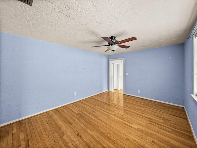 unfurnished room featuring light hardwood / wood-style flooring, a textured ceiling, and ceiling fan