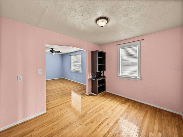 spare room featuring a textured ceiling, light hardwood / wood-style floors, and ceiling fan