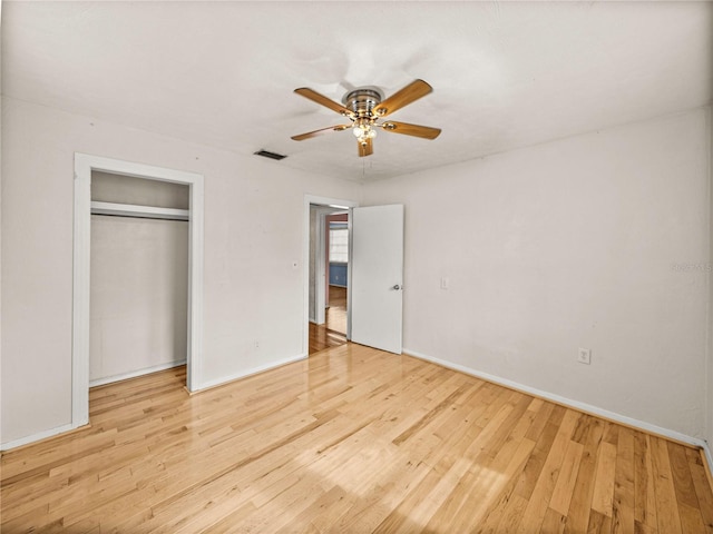 unfurnished bedroom with a closet, light wood-type flooring, and ceiling fan