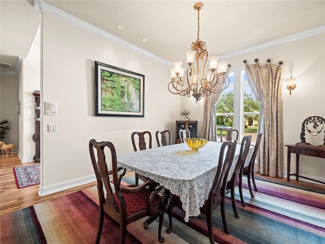 dining room with ornamental molding, a notable chandelier, and dark hardwood / wood-style floors