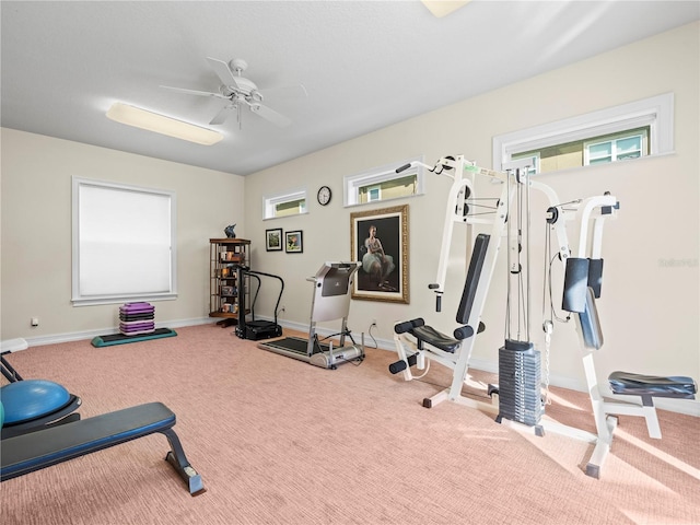 workout room featuring ceiling fan and light colored carpet