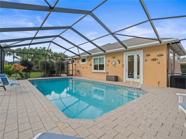 view of swimming pool featuring french doors, glass enclosure, and a patio area