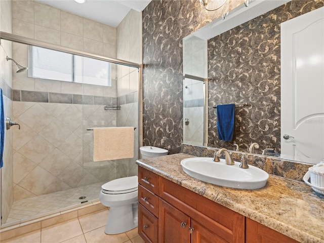 bathroom featuring vanity, walk in shower, tile patterned flooring, and toilet