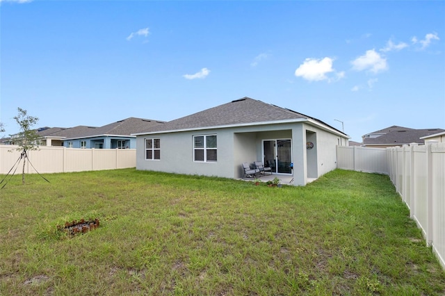 rear view of property with a lawn and a patio area