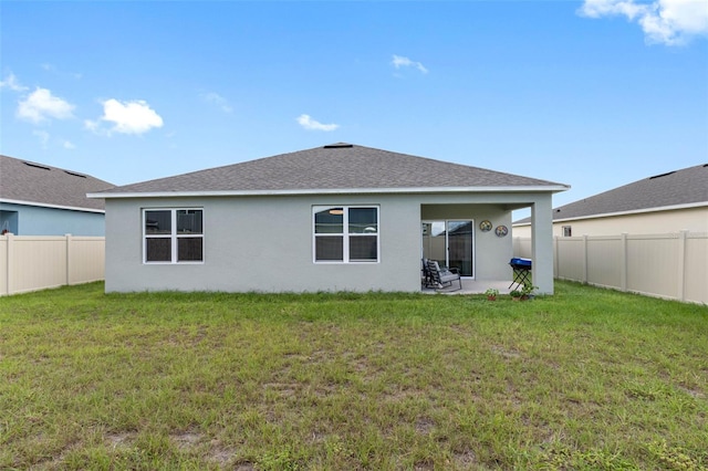 rear view of property featuring a patio and a yard