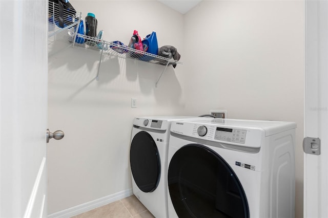 laundry room with independent washer and dryer and light tile patterned flooring