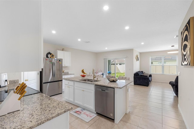 kitchen featuring stainless steel appliances, a center island with sink, a healthy amount of sunlight, and white cabinets