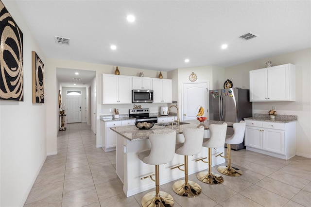 kitchen with white cabinetry, sink, a center island with sink, and stainless steel appliances