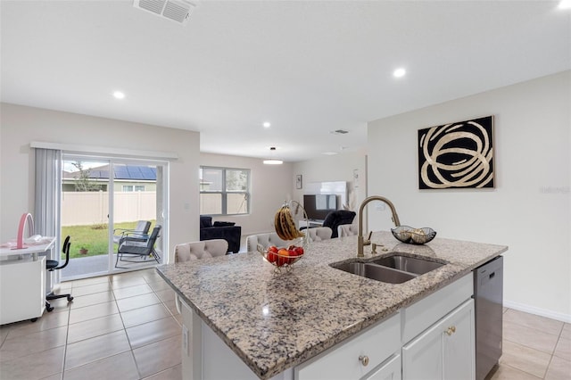 kitchen with a center island with sink, sink, light stone countertops, white cabinets, and dishwasher