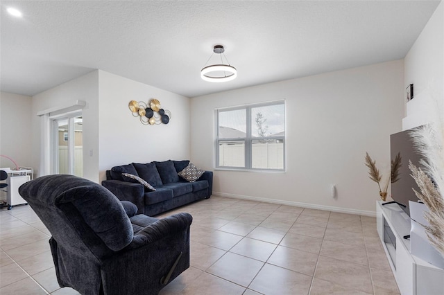 tiled living room featuring a textured ceiling